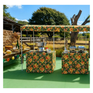 Barraquinhas gourmet com estampa florida de chita para festa junina, equipadas com máquina de algodão doce e rechauds de buffet da Festas Laura Show Gourmet.