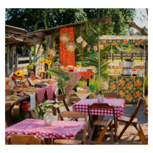 : Buffet de Festa Junina com mesa de doces típicos, decoração rústica com chita e barraquinhas gourmet da Festas Laura Show Gourmet.
